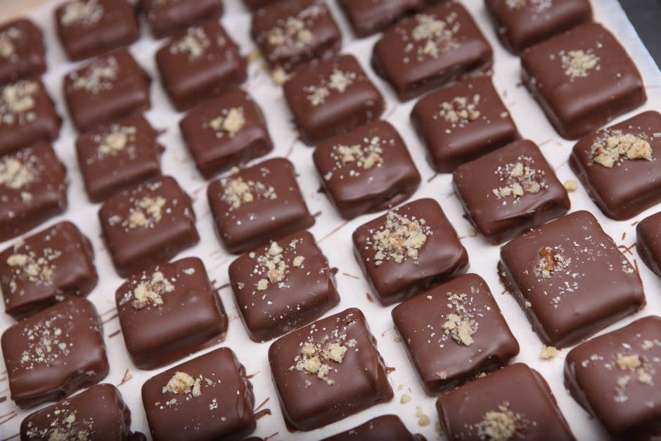 Chocolate covered toffee cools on a piece of parchment paper.